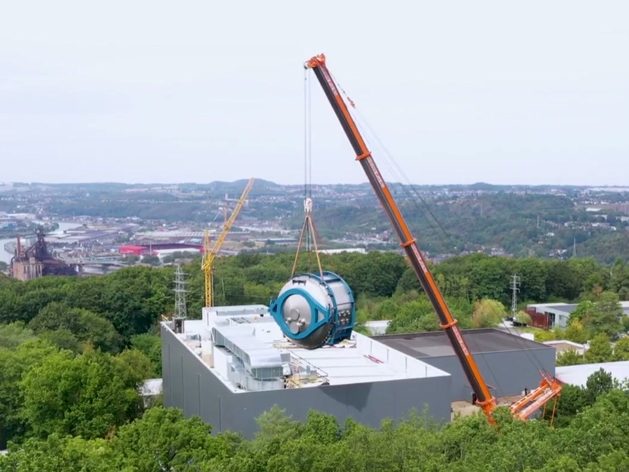 Luchtfoto: 700-tonskraan hijst de vacuümkamer boven het dak van het Centre Spatial de Liège