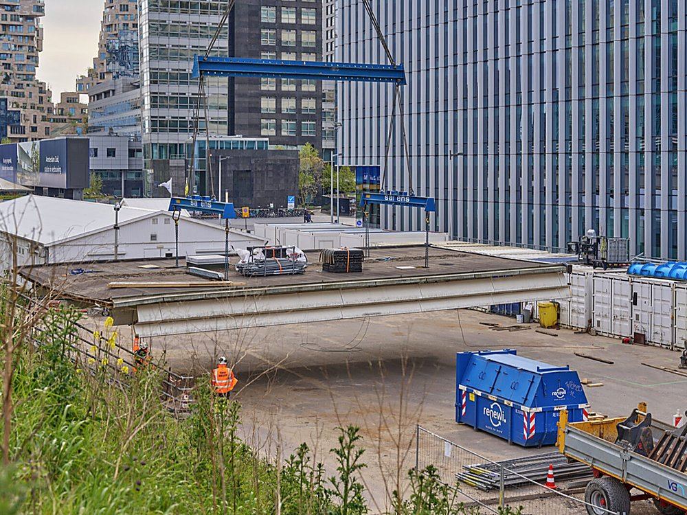 Sarens-kranen hijsen een perronkap op het bouwterrein bij Spoorslag